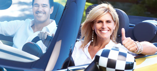 pareja conduciendo un descapotable