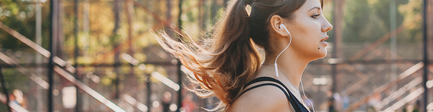 Mujer corriendo con cascos puestos