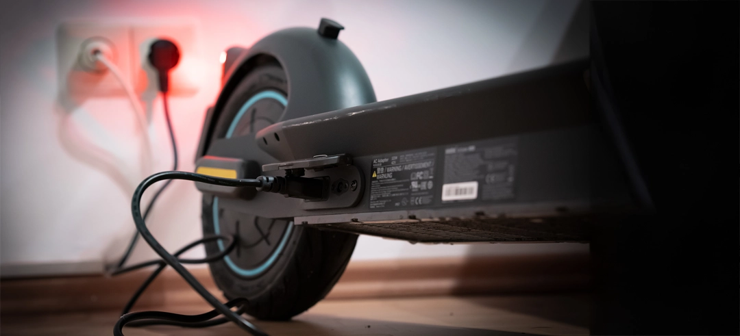 Patinete eléctrico cargando en un enchufe de casa