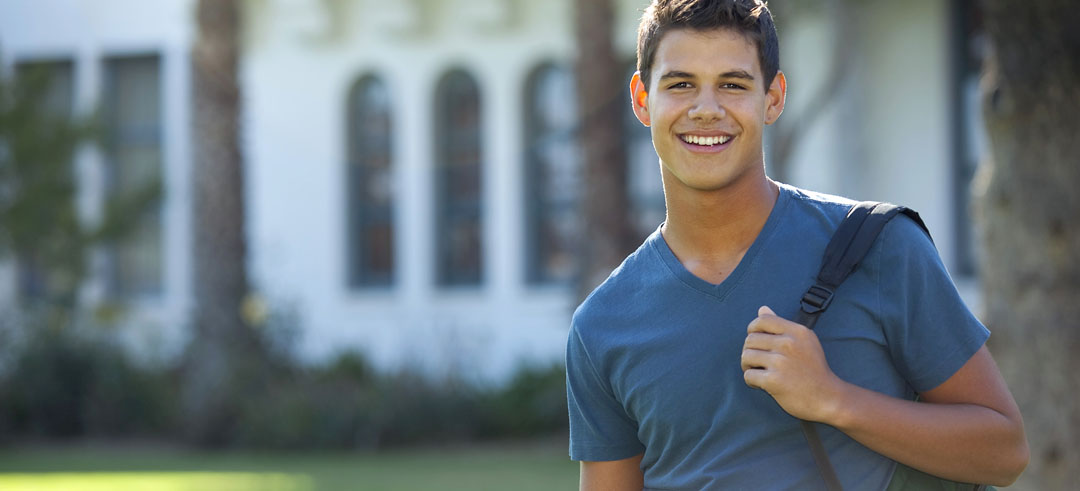 Joven estudiante sonriendo con la mochila sobre un hombro